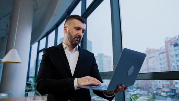 Biznesmen Średnim Wieku Stoi Przy Oknie Laptopem Człowiek Kończy Pracę — Wideo stockowe