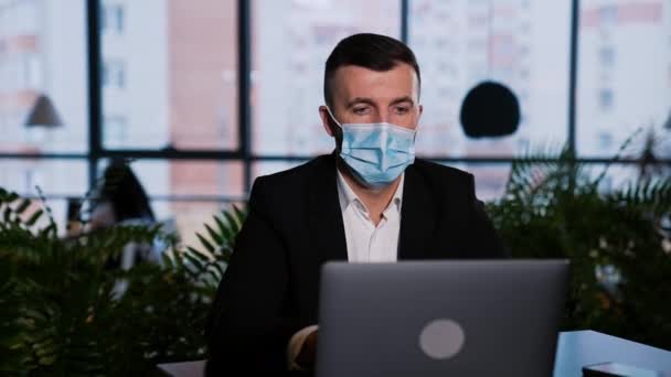 Zakenman Met Een Chirurgisch Masker Werkt Laptop Man Zit Achter — Stockvideo