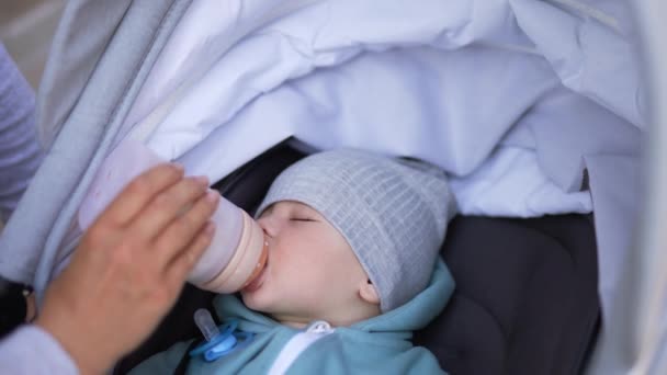 Sleepy Schattige Baby Wordt Gevoed Uit Fles Tijdens Het Lopen — Stockvideo