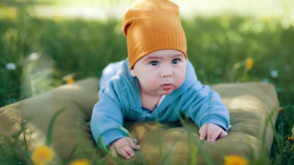 Słodki Chłopczyk Niebieskim Ogólnie Leży Brązowej Poduszce Zdrowe Dziecko Leży — Wideo stockowe