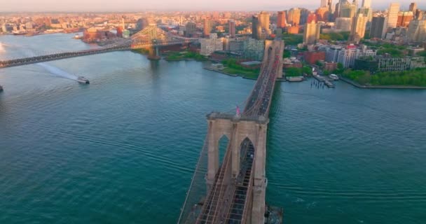 非常棒的布鲁克林大桥 交通繁忙 漂亮的游艇划破了东河蓝色水面的光滑表面 阳光照射下的纽约城市景观令人难以置信 — 图库视频影像