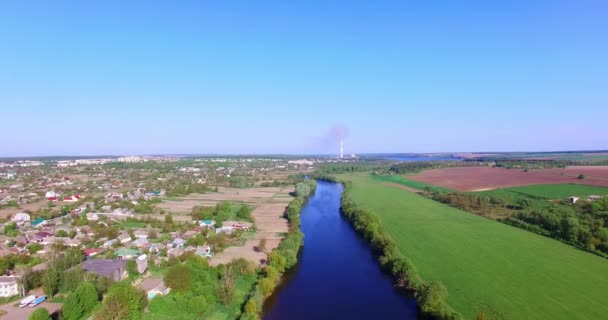 薄い青い川に囲まれたプライベートハウスを持つ大きな村 水路の反対側にある農村地帯 トップビュー — ストック動画