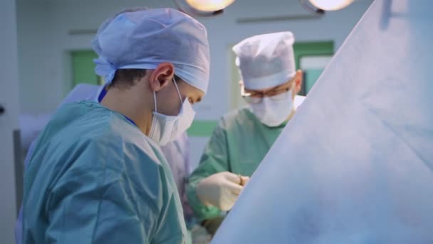Drużyna Męskich Chirurgów Ciężko Pracuje Nad Operacją Lekarz Okularach Szycie — Wideo stockowe