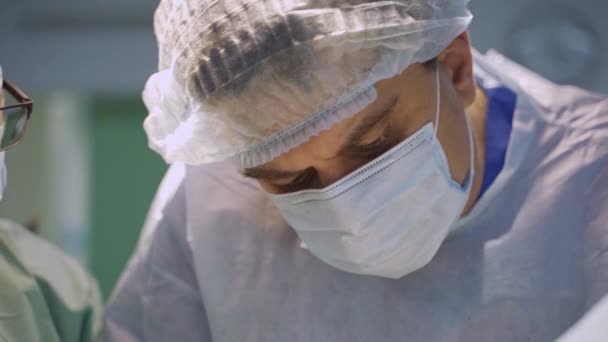 Lekarze Czapkach Maskach Pochylają Głowy Żeby Lepiej Widzieć Operowany Obszar — Wideo stockowe