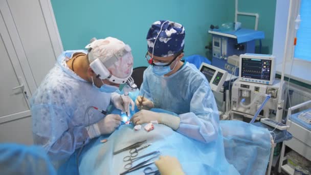 戴眼镜的医生们用金属工具给病人戴上了 医生背后的医疗设备 — 图库视频影像