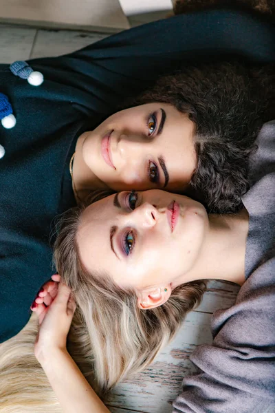 Kapalı mekan moda güzel bayanlar birlikte yaşam tarzı. Güzel kız arkadaşlar süveter içinde portre çizerler..