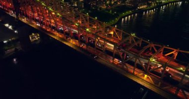Gece vakti büyük köprüde trafik sıkışıktı. Fırlatma karanlık nehir boyunca köprünün altından geçiyor. Üst görünüm.