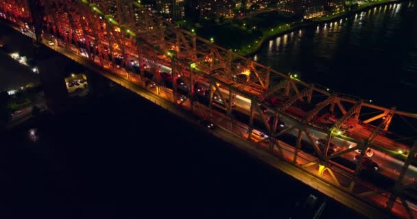 夜間に大きな橋の上の交通渋滞 暗い川沿いの橋の下で打ち上げました トップビュー — ストック動画
