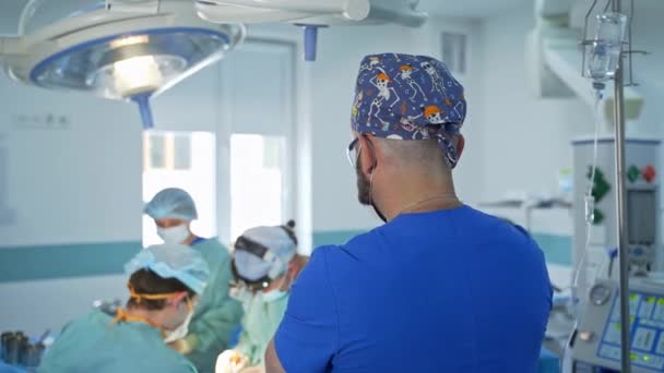 Sırtında Iskeletleri Olan Komik Şapkalı Doktorun Ameliyatı Izlemesi Erkek Anestezi — Stok video