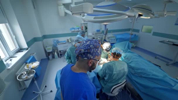 Male Doctors Performing Surgery Patient Arm Anesthesiologist Watches Operation Standing — Stock Video