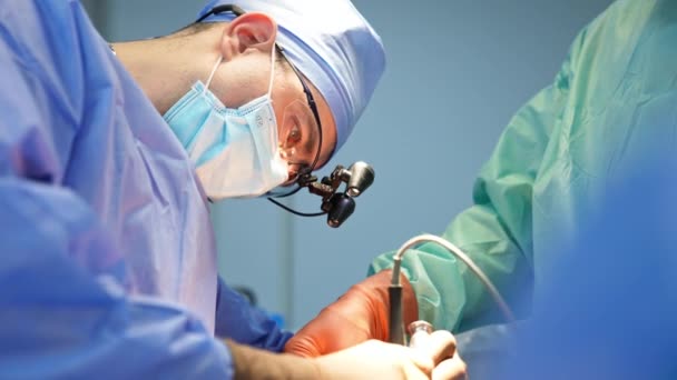 Mannelijke Chirurg Kijkt Gefocust Het Operatiegebied Door Middel Van Apparaatglazen — Stockvideo