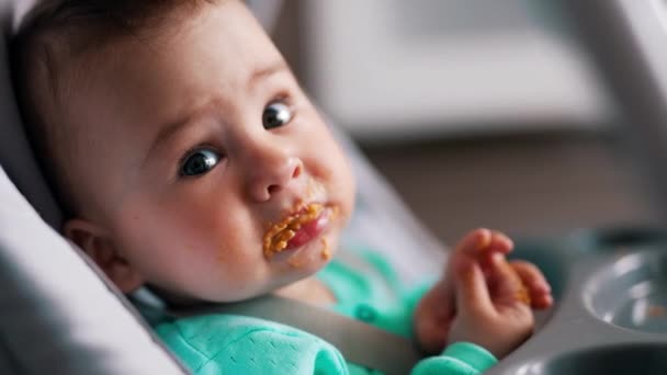 Leuke Smerige Baby Het Eten Kindergezicht Besmeurd Met Oranje Spul — Stockvideo