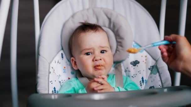 Babynahrung Aus Dem Löffel Mutter Gibt Ihrem Sohn Das Orangefarbene — Stockvideo