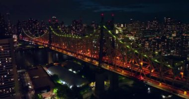 Gece vakti Queensboro Köprüsü 'nün altını çok güzel çizilmiş. İnsansız hava aracı canlı şehrin üzerinde uçuyor. New York 'un milyarlarca ışığı.