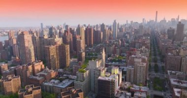 New York 'ta yoğun bir şekilde inşa edilmiş Manhattan bölgesi. Pembe gökyüzünün zemininde çeşitli yükseklikte ve dizaynlı güzel binalar. Yukarıdan görüntüle.