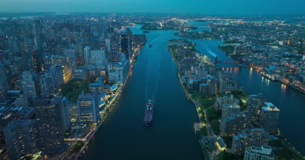 大船缓缓地驶过深蓝色的河流 驶向皇后堡大桥 令人惊叹的纽约城市景观数十亿的灯光 空中景观 — 图库视频影像
