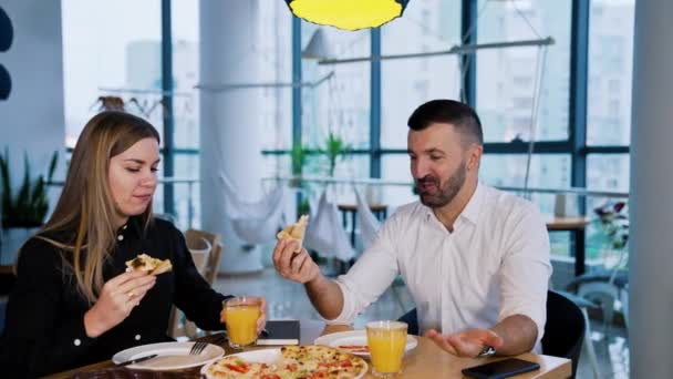笑顔の同僚がピザを持って話している ビュッフェでオフィスワーカーのランチ休憩 — ストック動画