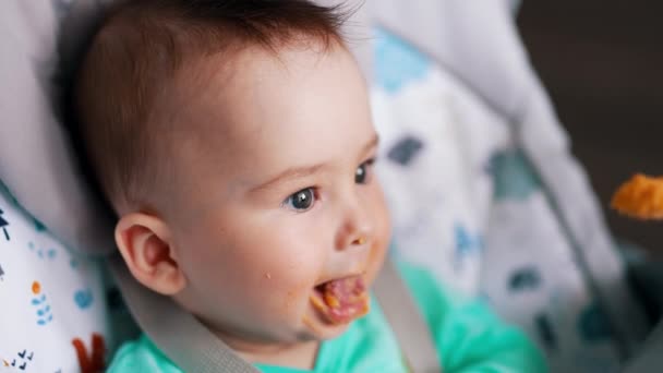 妈妈在用勺子给她儿子吃东西 给婴儿营养的概念 靠近点模糊的背景 — 图库视频影像