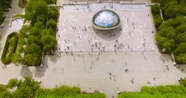 Chicago Bean 'in Bulut Kapısı Millennium Park meydanında. Anıtın etrafında bir sürü insan dolaşıyor. Üst görünüm.