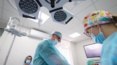 Doktor ameliyat odasındaki ekranda enstrüman uygulamasını izliyor. Düşük açı görünümü.