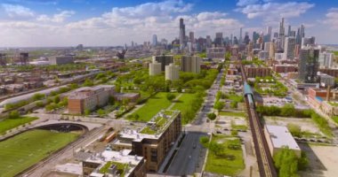 Şehirden geçen yol ve paralel metro rayları. Gündüz vakti yeşil Chicago bölgesinin güneşli manzarası. Yukarıdan görüntüle.