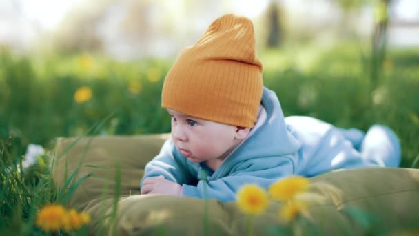 Очаровательный Мальчик Голубом Оранжевой Шапочке Природе Милый Ребенок Отдыхает Траве — стоковое видео