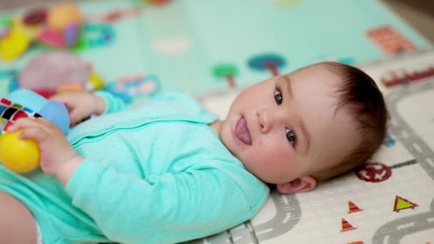 Hübsches Baby Liegt Auf Dem Rücken Blauer Kleidung Und Hält — Stockvideo