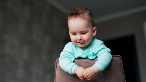 Roztomilé Dítě Stojí Židli Dívá Dolů Roztomilé Dítě Ukazuje Jazyk — Stock video