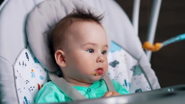 Sandalyede Oturan Bir Bebeği Beslemek Şirin Bir Çocuk Kaşıkla Ağzını — Stok video