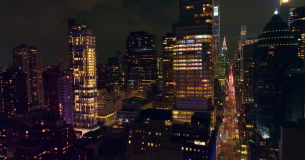 长长的街道 繁忙的交通穿过令人惊奇的建筑 漂亮的摩天大楼 夜间窗户上有灯光 — 图库视频影像