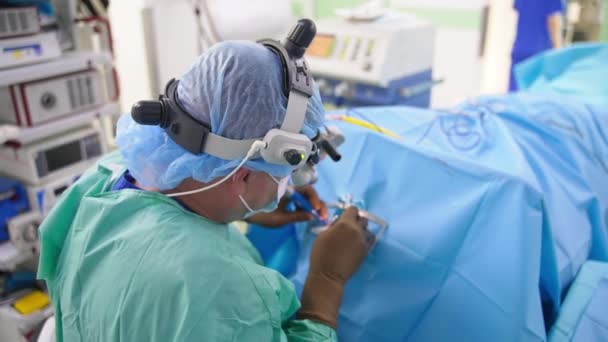안경을 의사는 장비를 사용하여 앉습니다 등에서 외과의사의보기 — 비디오