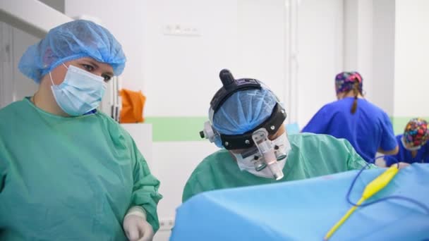 Otorrinolaringólogo Cirujano Sentado Cerca Del Paciente Cubierto Con Tela Enfermera — Vídeo de stock