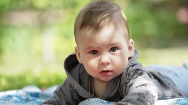 Zdrowy Biały Dzieciak Szarej Bluzie Leży Naturze Piękne Dziecko Uderza — Wideo stockowe