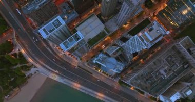 Rıhtımdaki otoyoldan hızlı araçlar geçiyor. İHA Chicago şehir merkezindeki gökdelenlerin üzerinde uçuyor..