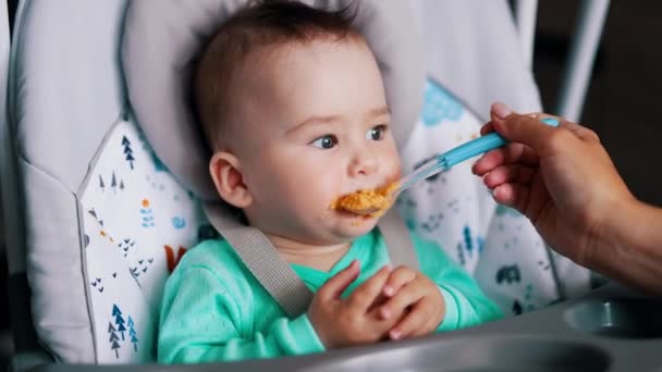 Küçük Bebek Sandalyede Oturmuş Sebze Yiyor Yemek Saatinde Dilini Çıkaran — Stok video