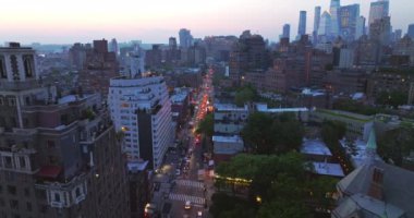 Alacakaranlıkta New York sokaklarında ışıkları yanan sayısız araba hareket ediyor. Gökyüzünden güzel bir şehir manzarası.