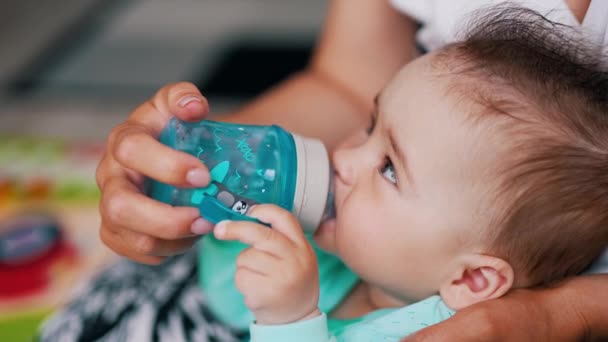 Baby Dricksvatten Från Plastflaska Med Napphållare Mamma Håller Flaska Sin — Stockvideo