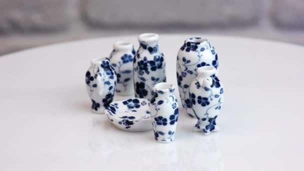 不同的花瓶 蓝色的花纹和一个盘子在旋转的桌子 可敬的小陶器特写 — 图库视频影像