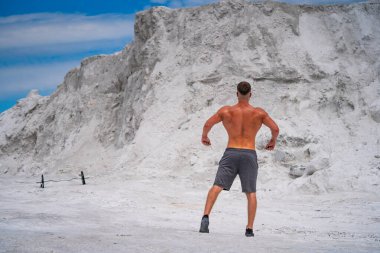 Genç adam beyaz tuz tarlasında koşuyor.