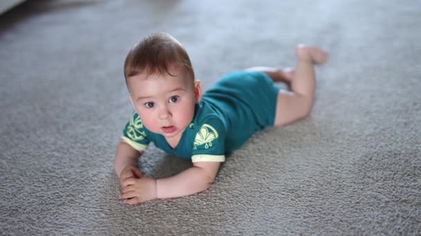 놀라움으로 카메라를 올려다 바닥에 재미있는 아이는 다리를 바닥에 혔습니다 — 비디오