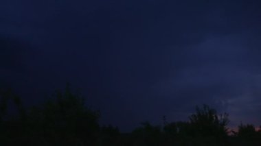 Kırsal bölgede şiddetli bir fırtına kopuyor. Koyu mavi gökyüzü yıldırımdan morarır. Köyde gece.