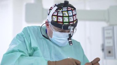 Cerrah burun burun ameliyatı için aletler uygulamakla meşgul. Modern cerrahi odasında otolarengoloji ameliyatı.