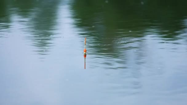 平和な川に残っている漁船 水面に小さな円が現れている ブラーレッド バックドロップ — ストック動画
