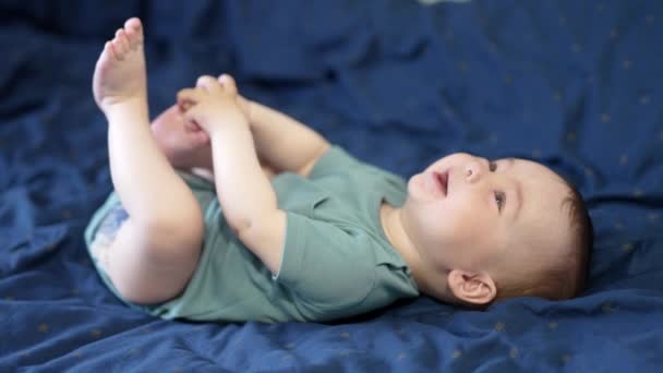 Güzel Küçük Çocuk Yatakta Yatarken Hareket Ediyor Bacaklarıyla Ilgilenen Sevimli — Stok video