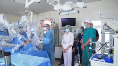 İnsan doktor ve robot ekipmanların işbirliğiyle cerrahi operasyon gerçekleştirildi. Hastanenin tıbbi personeli ameliyatı ekrandan izliyor..