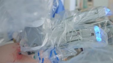 Sterilite işlemi için plastik kaplı Da Vinci robotik kolları. Hastanın vücudundaki açıklıkta yüksek hassasiyetli ekipman hareket ediyor..