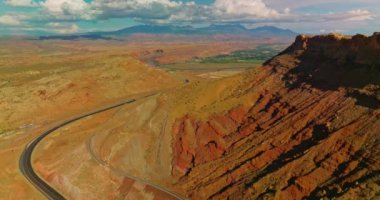 Utah Ulusal Parkı 'ndaki kayalar, çöller ve yeşil vadiler. İnsansız hava aracı kanyonun eteğindeki otoyolda uçuyor. Hava perspektifi.
