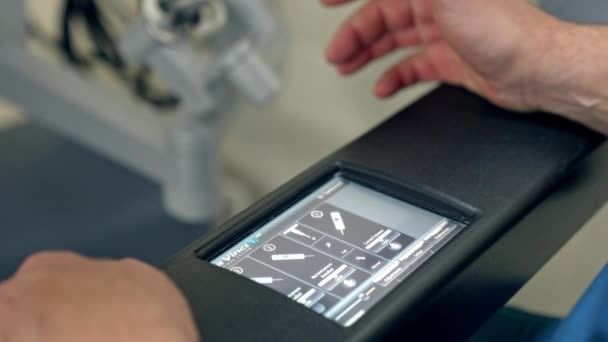 ロボットマシンのキーボード付きセンサースクリーン 未来的なダヴィンチロボットを操作する医師の男性の手 クローズアップ — ストック動画