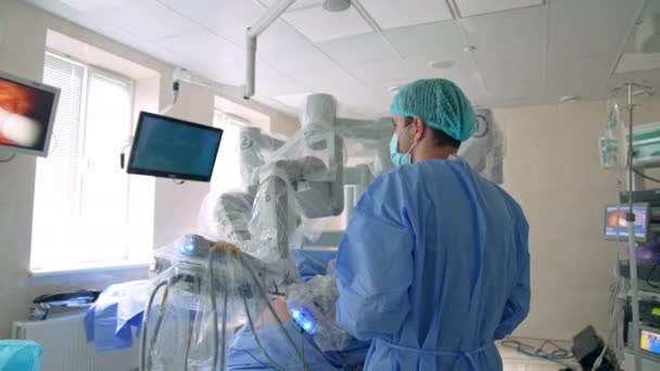 Συγκεντρωμένος Άντρας Γιατρός Στέκεται Κοντά Στο Χειρουργικό Ρομπότ Ντα Βίντσι — Αρχείο Βίντεο
