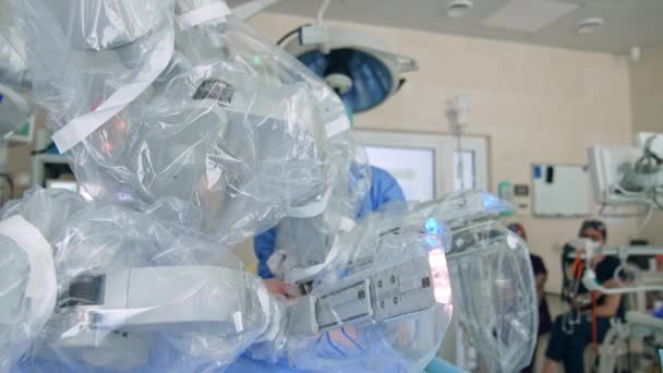 近代手術室で働く未来派ダ ヴィンチロボット 手術の過程を観察するバックドロップの医学 ブラーレッド バックドロップ — ストック動画